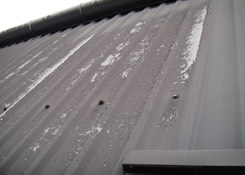 This image also shows the dilapidation to the Plastisol paint system after 15 year. Weston painting contractors of Cardiff South Wales had to completely removed all traces of dilapidation by brushing, sanding and power washing of all metal cladding sub-straights prior to any painting taking place.